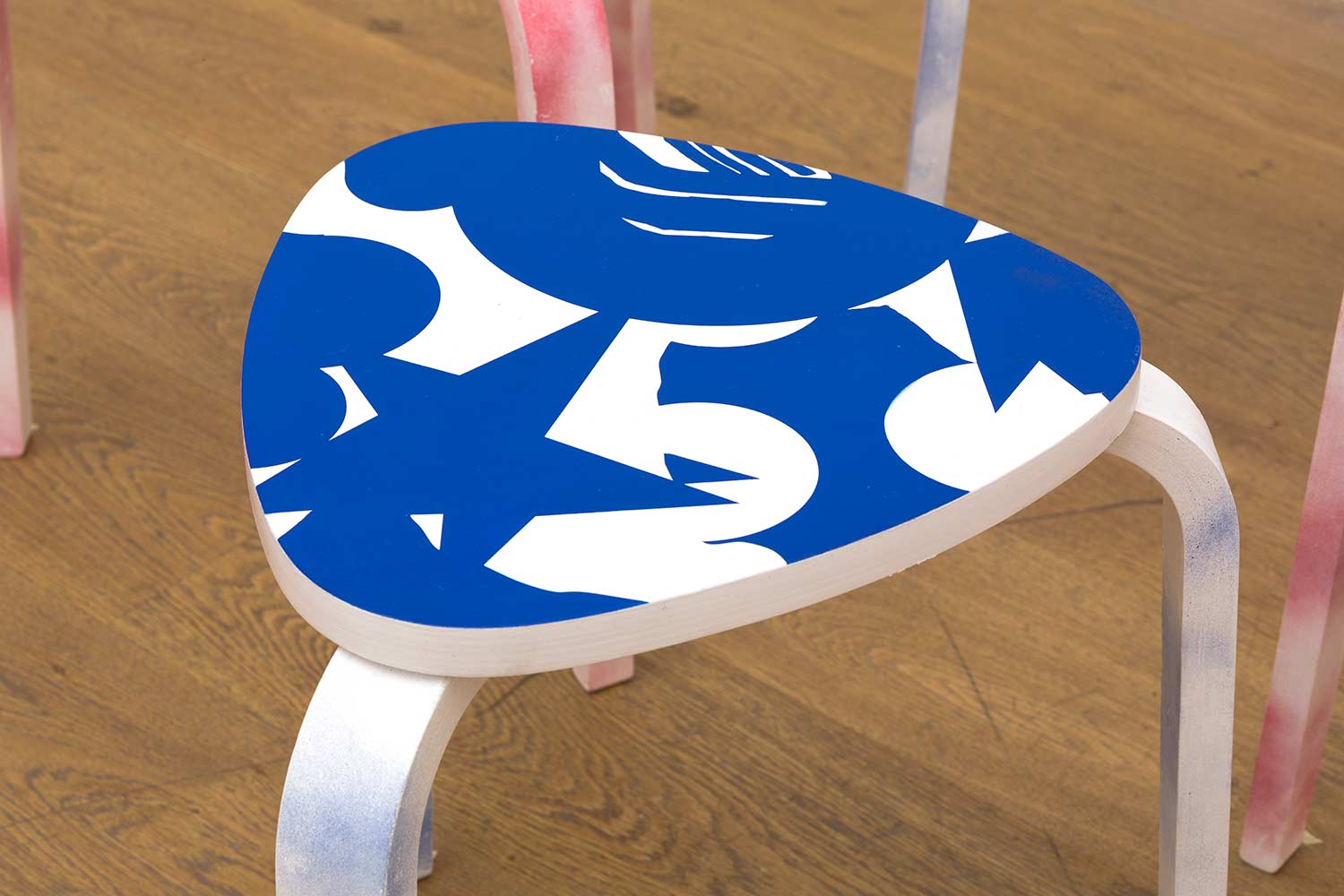 Close-up of painted stool by Darren John showing blue abstract graphic pattern for Hospital Rooms