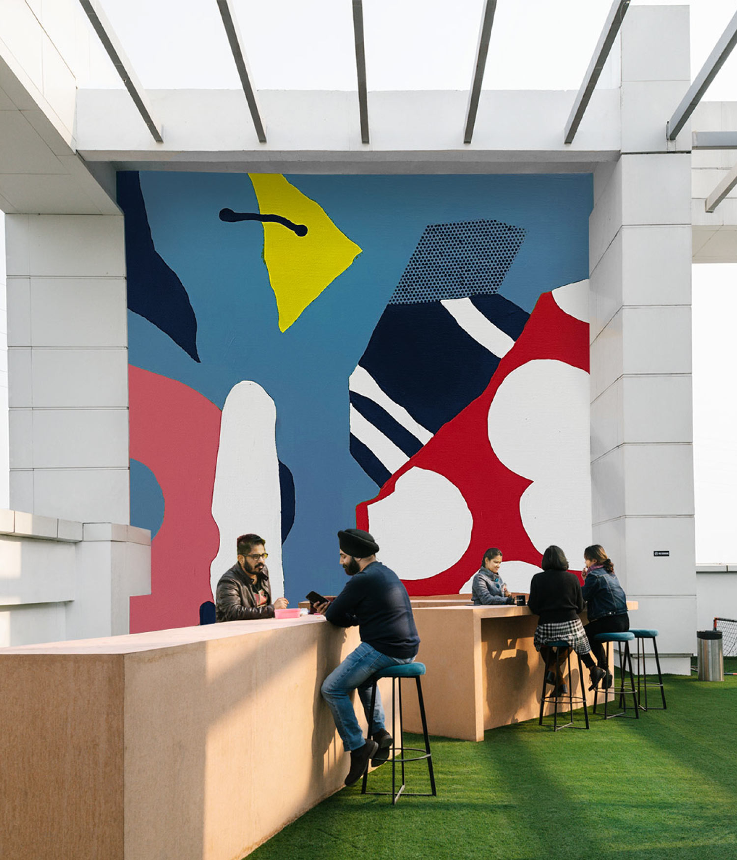 Large-scale interior mural by Darren John in public space with people seated in foreground
